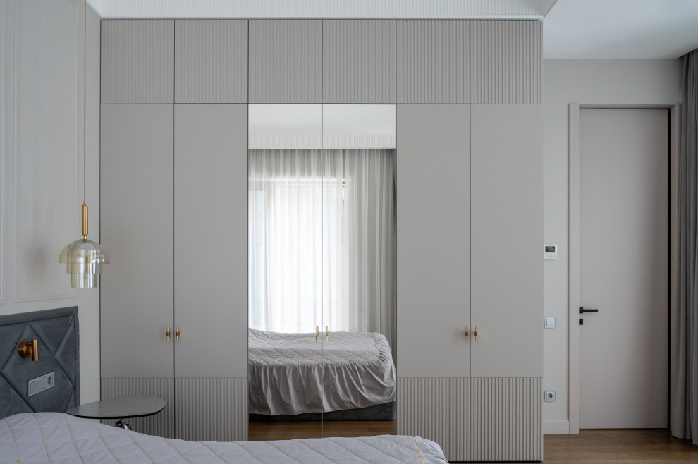 Foto de dormitorio principal contemporáneo grande con paredes grises, suelo de madera en tonos medios y suelo marrón