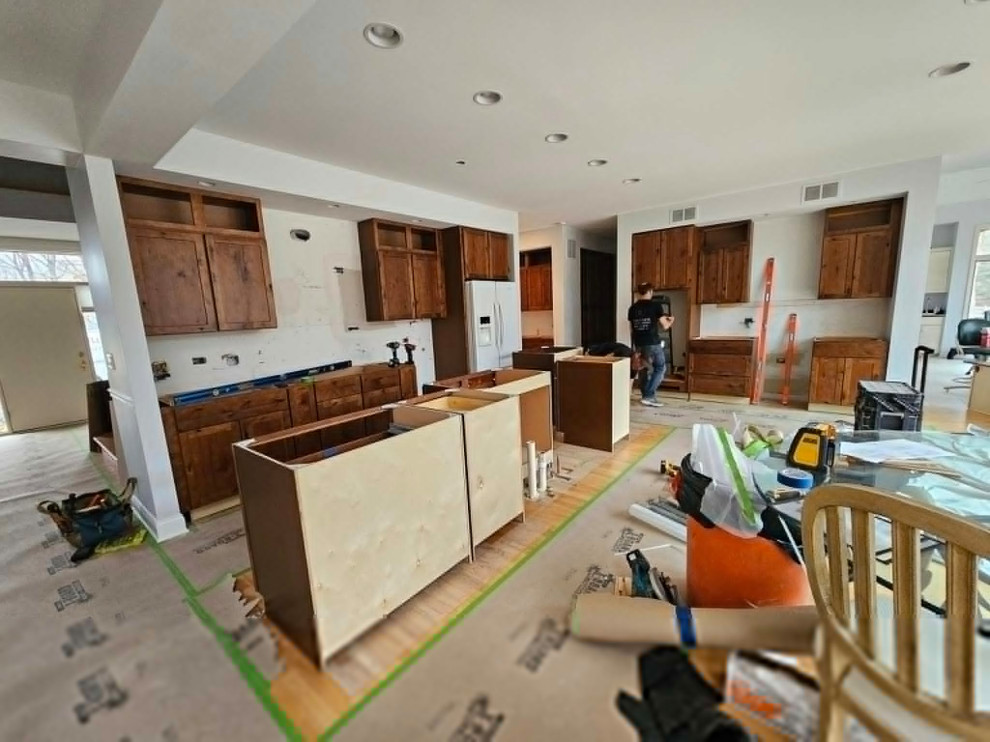 Example of a large transitional medium tone wood floor and brown floor eat-in kitchen design in Chicago with an undermount sink, shaker cabinets, medium tone wood cabinets, quartz countertops, multicolored backsplash, stone tile backsplash, stainless steel appliances, an island and white countertops