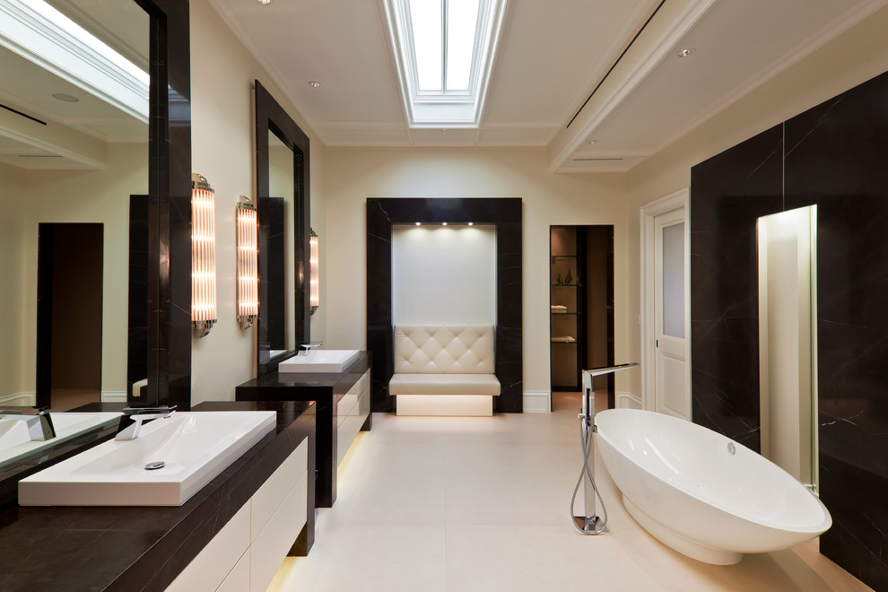 Photo of a contemporary bathroom in Miami with flat-panel cabinets, white cabinets, a freestanding tub and beige walls.