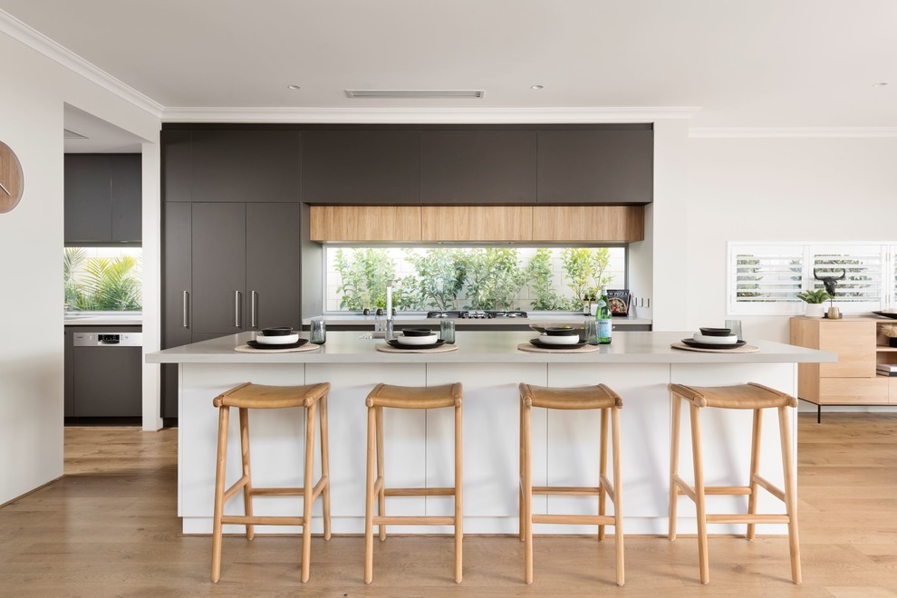 Design ideas for a contemporary galley kitchen in Perth with flat-panel cabinets, grey cabinets, window splashback, light hardwood floors, with island, brown floor and white benchtop.