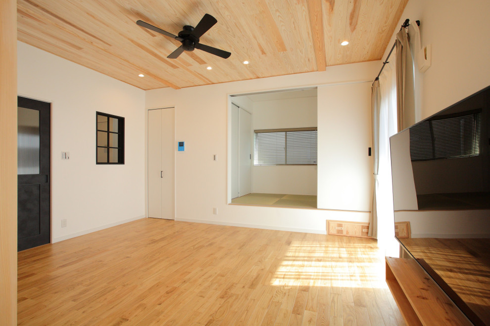 Country Wohnzimmer mit weißer Wandfarbe, hellem Holzboden, gelbem Boden, Holzdecke und Tapetenwänden in Sonstige