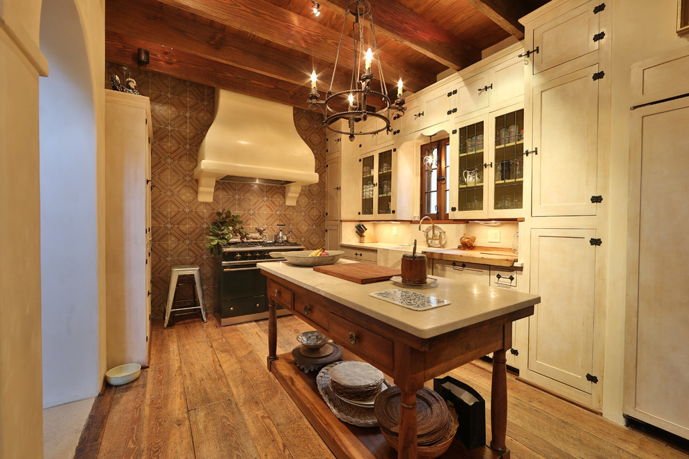 Open concept kitchen - mid-sized rustic single-wall medium tone wood floor and brown floor open concept kitchen idea in Austin with a farmhouse sink, shaker cabinets, white cabinets, an island, limestone countertops, multicolored backsplash and ceramic backsplash
