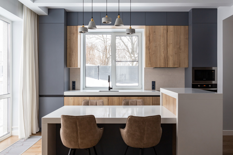 Свежая идея для дизайна: прямая кухня в современном стиле с обеденным столом, плоскими фасадами, серыми фасадами, столешницей из кварцевого агломерата, островом и белой столешницей в частном доме - отличное фото интерьера
