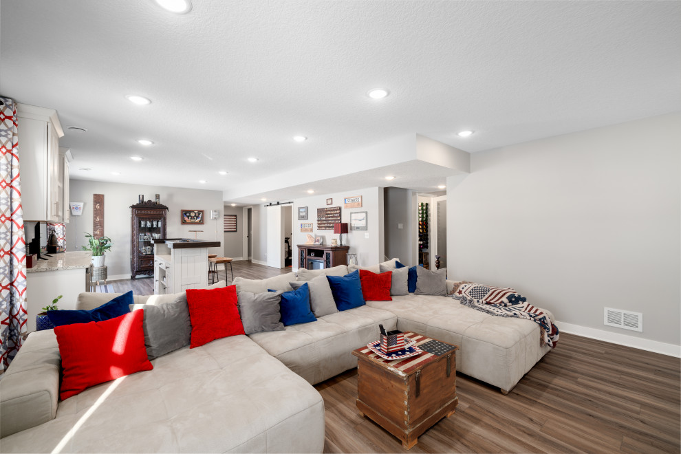 Inspiration for a large open concept family room in Other with a home bar, grey walls, vinyl floors, no fireplace, a freestanding tv and brown floor.