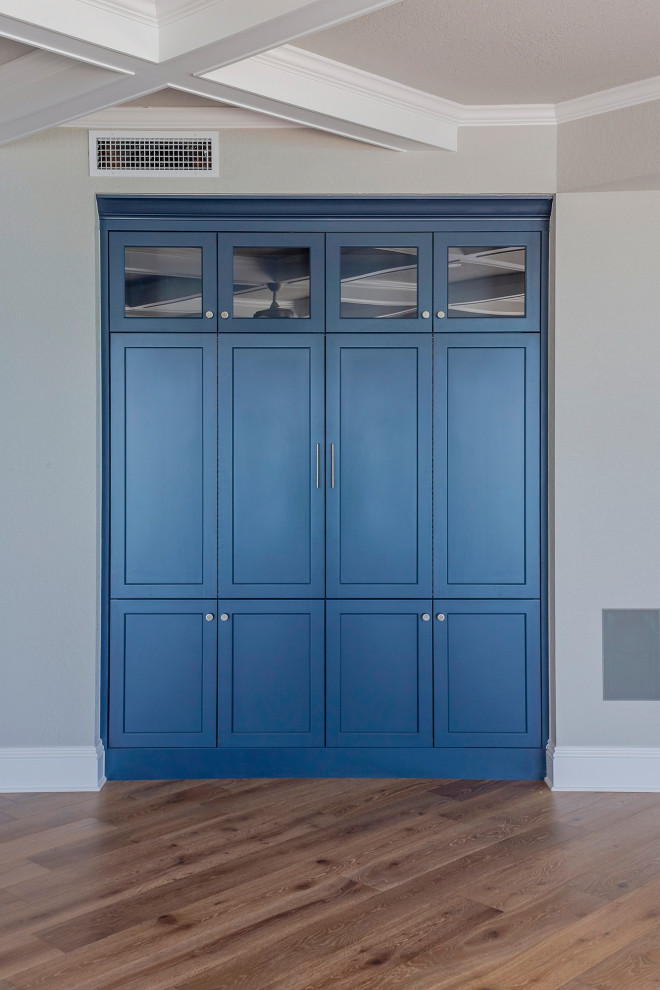 Идея дизайна: встроенный шкаф среднего размера, унисекс в стиле модернизм с синими фасадами, светлым паркетным полом, коричневым полом, балками на потолке и плоскими фасадами