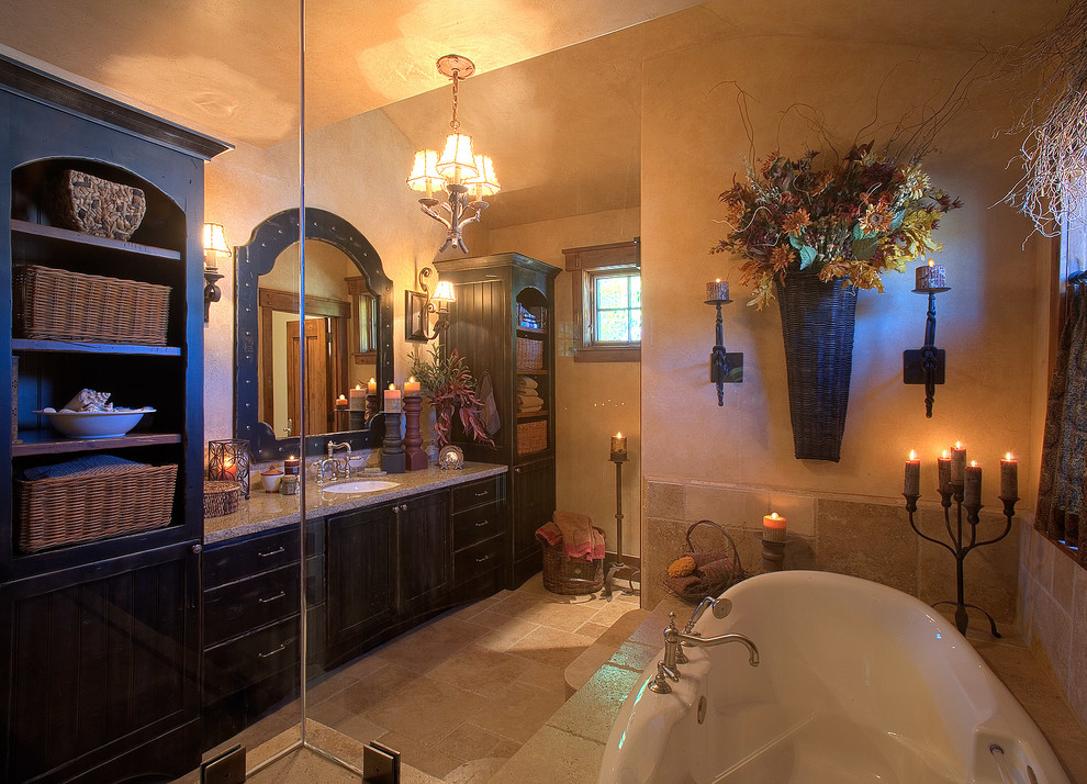 Mid-sized arts and crafts master bathroom in Salt Lake City with shaker cabinets, distressed cabinets, a drop-in tub, a corner shower, beige tile, travertine, beige walls, travertine floors, an undermount sink and granite benchtops.