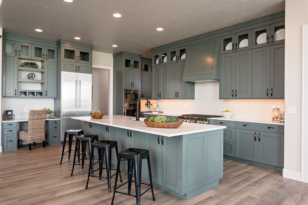 Design ideas for a large transitional u-shaped eat-in kitchen in Boise with white splashback, stainless steel appliances, with island, shaker cabinets, a farmhouse sink, laminate floors, grey floor, blue cabinets, quartzite benchtops, mosaic tile splashback and white benchtop.