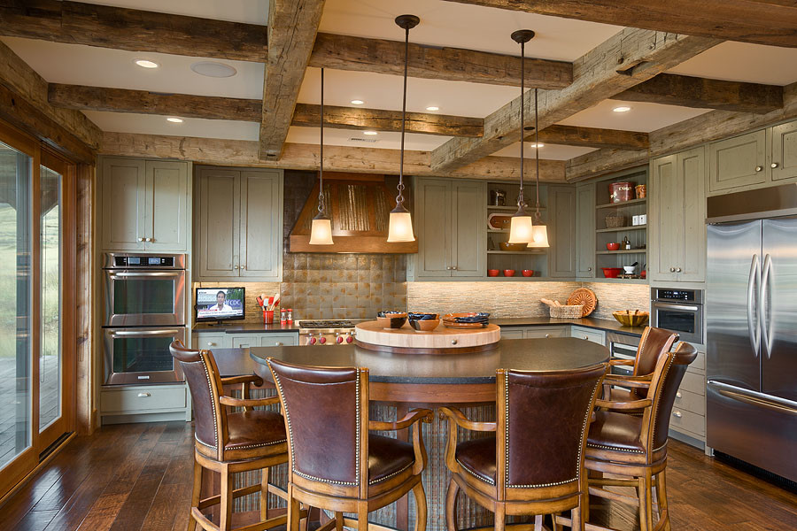 Inspiration for a large rustic l-shaped dark wood floor kitchen remodel with flat-panel cabinets, green cabinets, granite countertops, stone tile backsplash, stainless steel appliances, an island and black countertops