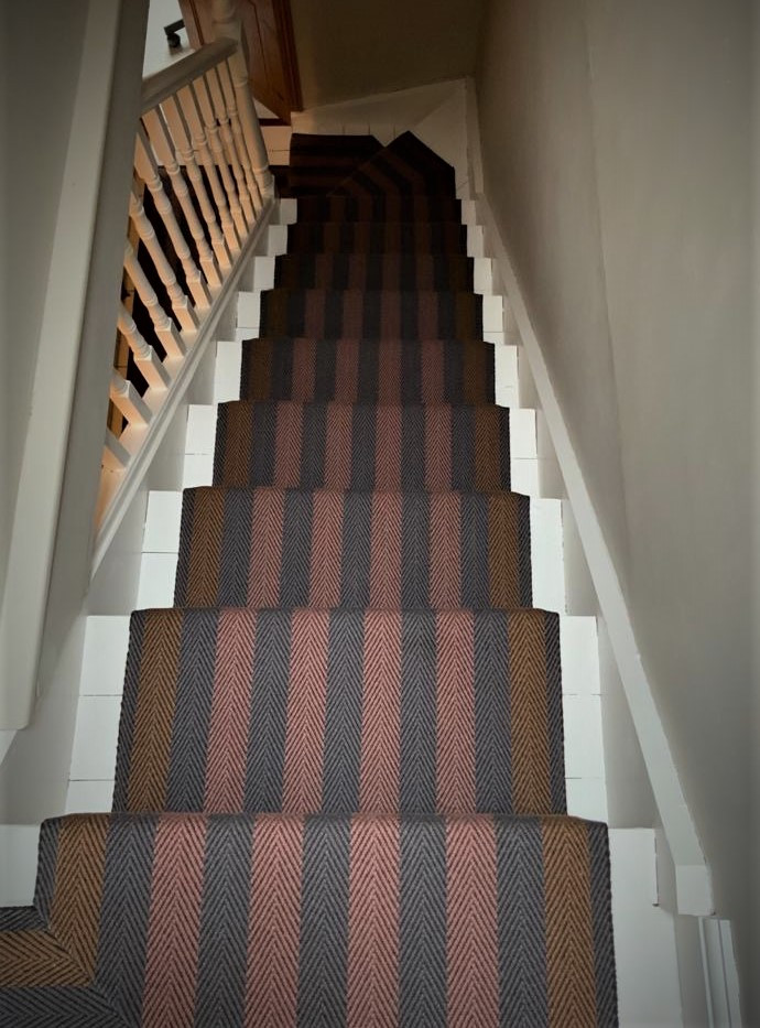 Example of a large trendy carpeted floating wood railing staircase design in Hertfordshire with carpeted risers