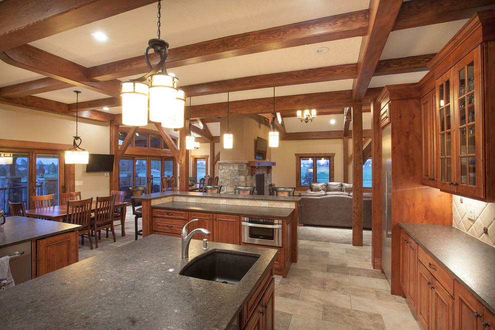 Design ideas for a large country u-shaped open plan kitchen in Denver with an undermount sink, recessed-panel cabinets, medium wood cabinets, soapstone benchtops, beige splashback, ceramic splashback, stainless steel appliances, ceramic floors and multiple islands.