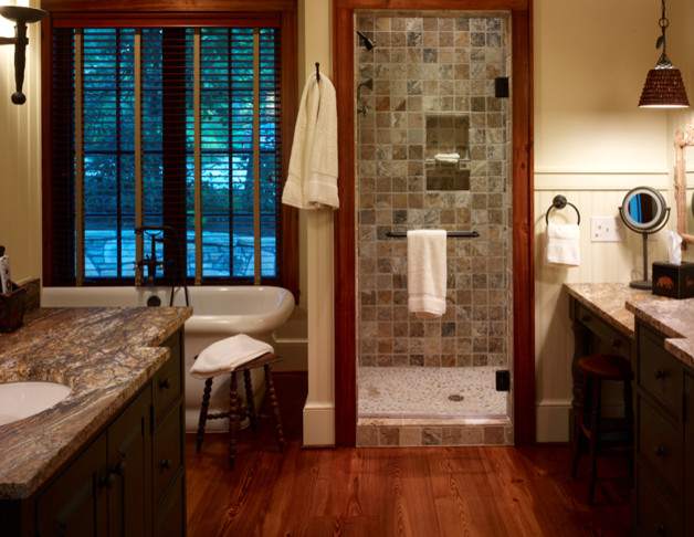 Large mountain style master beige tile and stone tile medium tone wood floor freestanding bathtub photo with an undermount sink, flat-panel cabinets, dark wood cabinets and beige walls