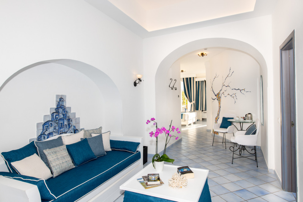 Esempio di una grande camera matrimoniale mediterranea con pareti bianche, pavimento con piastrelle in ceramica, pavimento turchese, soffitto ribassato e TV
