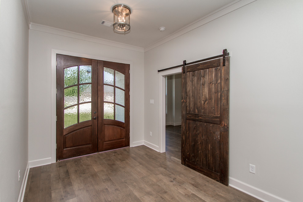 This is an example of a mid-sized traditional front door in Little Rock with grey walls, medium hardwood floors, a double front door, a dark wood front door and brown floor.
