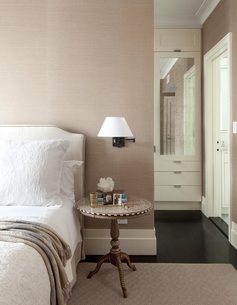 Contemporary bedroom in New York with beige walls and dark hardwood floors.
