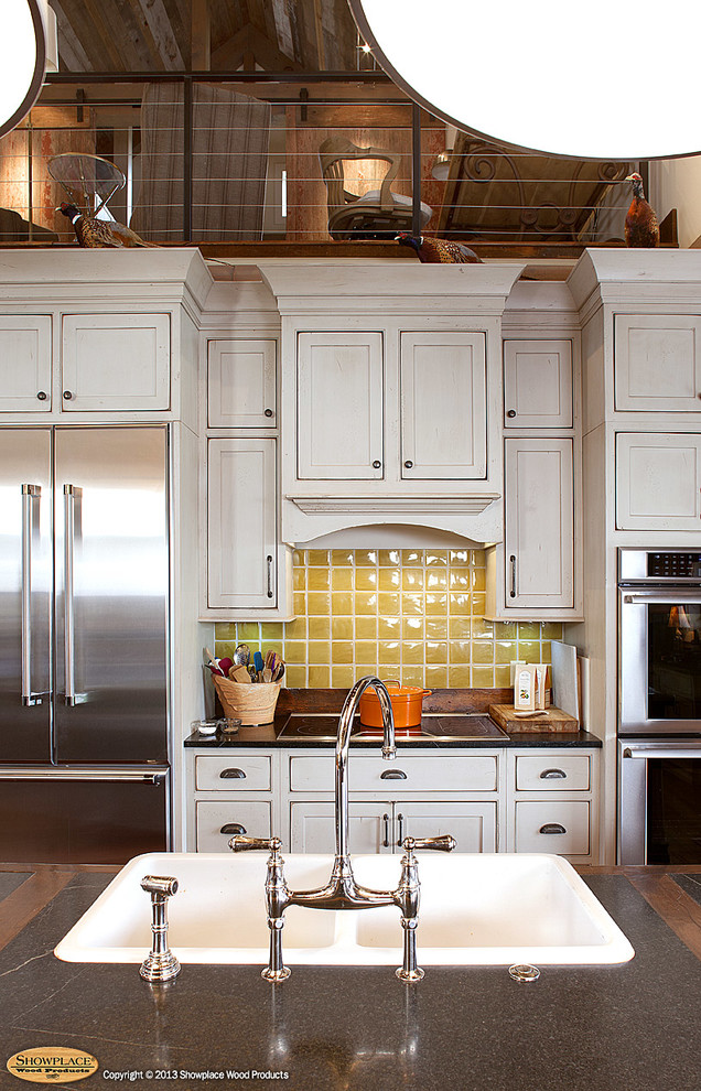 This is an example of a country eat-in kitchen in Other with a farmhouse sink, beaded inset cabinets, green cabinets, limestone benchtops, yellow splashback and stainless steel appliances.