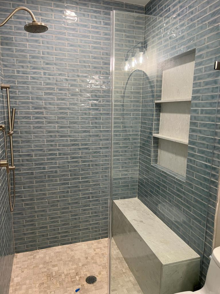 Design ideas for a mid-sized tropical kids bathroom in Houston with shaker cabinets, brown cabinets, a two-piece toilet, green tile, ceramic tile, beige walls, marble floors, an undermount sink, engineered quartz benchtops, white floor, a hinged shower door, white benchtops, a niche, a single vanity and a freestanding vanity.