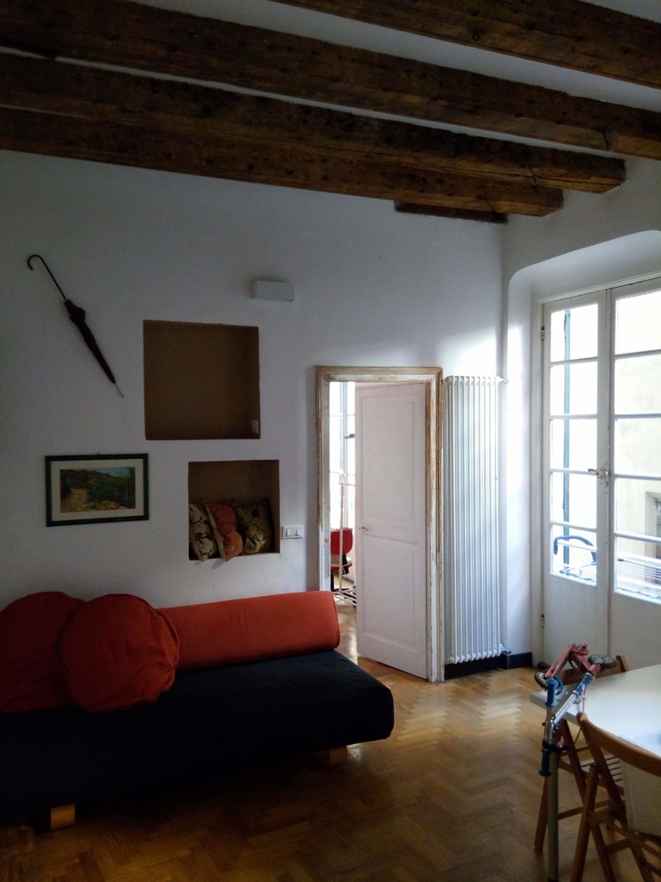 На фото: большая открытая гостиная комната в современном стиле с белыми стенами, светлым паркетным полом и с книжными шкафами и полками с
