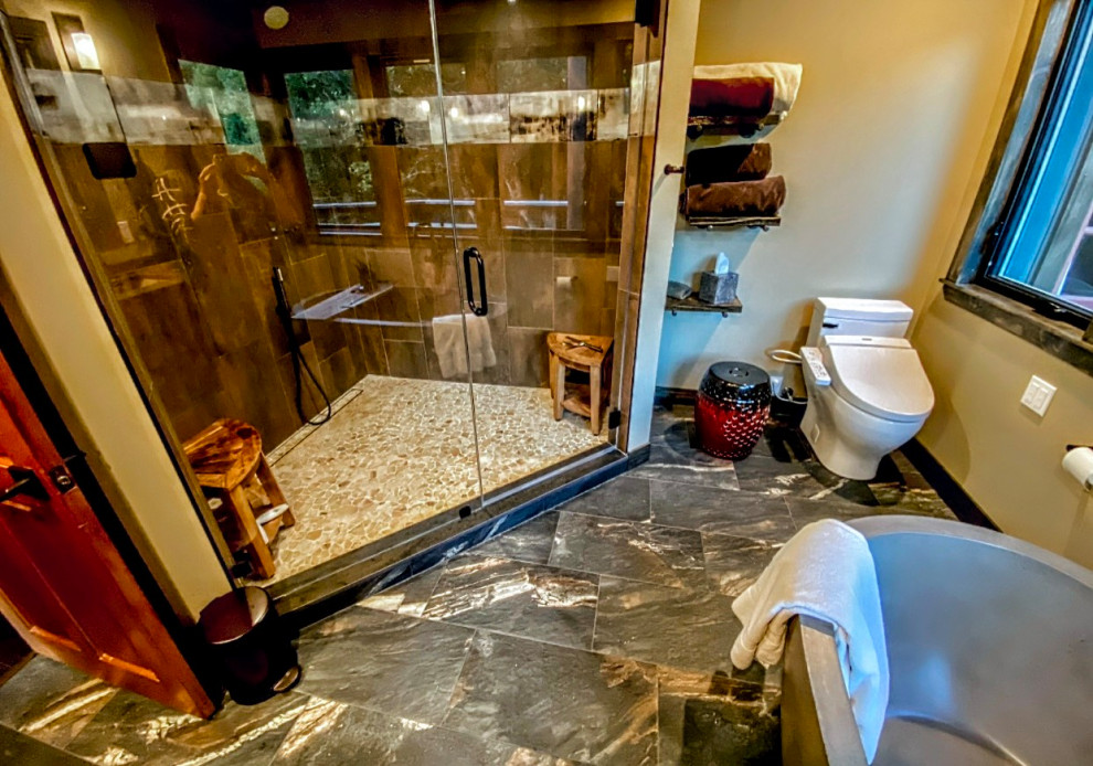 Inspiration för ett stort rustikt en-suite badrum, med ett fristående badkar, en hörndusch, en bidé, brun kakel, porslinskakel, beige väggar, klinkergolv i porslin, brunt golv och dusch med gångjärnsdörr