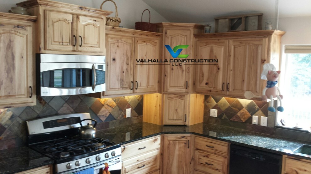 Eat-in kitchen - mid-sized rustic l-shaped medium tone wood floor eat-in kitchen idea with an undermount sink, recessed-panel cabinets, light wood cabinets, granite countertops, multicolored backsplash, stone tile backsplash, stainless steel appliances and an island