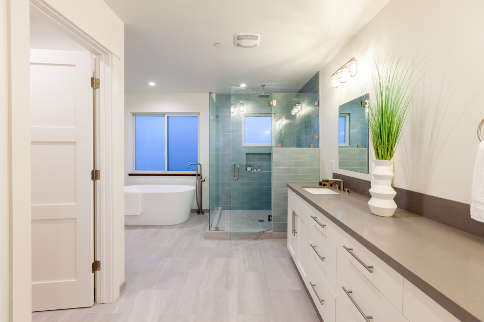 Photo of a large country master bathroom in San Diego with shaker cabinets, white cabinets, a freestanding tub, a corner shower, a two-piece toilet, green tile, glass tile, white walls, porcelain floors, an undermount sink, engineered quartz benchtops, grey floor, a hinged shower door, grey benchtops, an enclosed toilet, a double vanity and a built-in vanity.