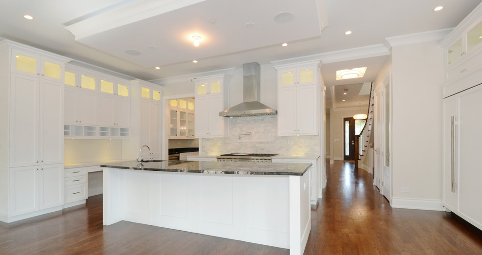 Example of a transitional kitchen design in Chicago with granite countertops, white backsplash, stainless steel appliances and an island