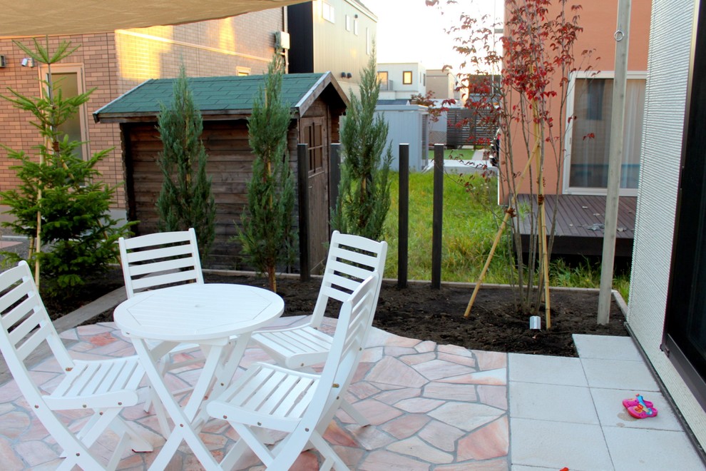 Contemporary back terrace in Other with a water feature and an awning.