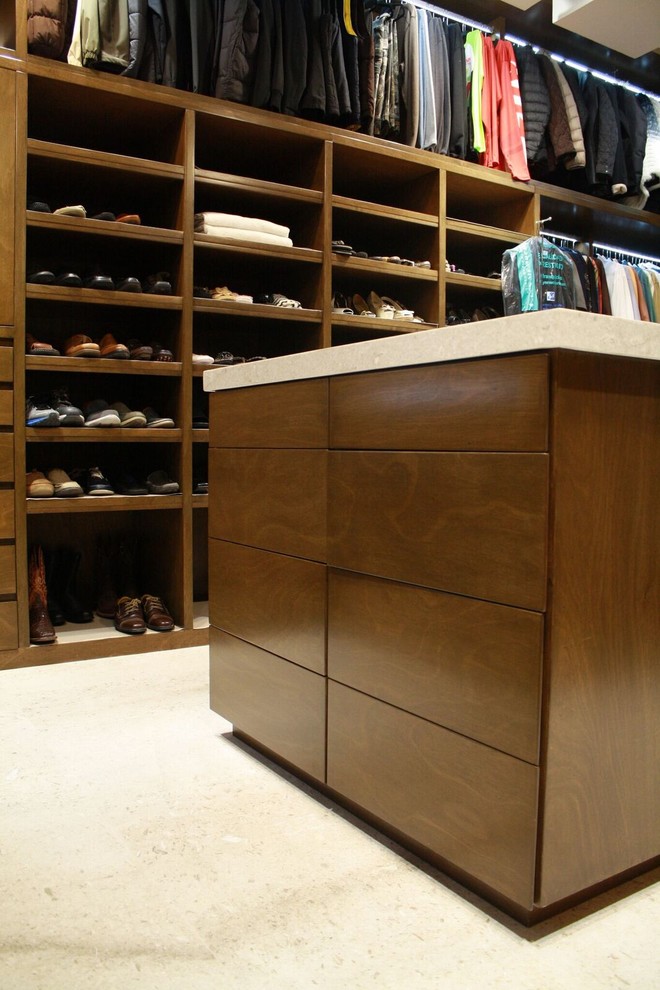Contemporary gender-neutral walk-in wardrobe in Other with flat-panel cabinets and medium wood cabinets.