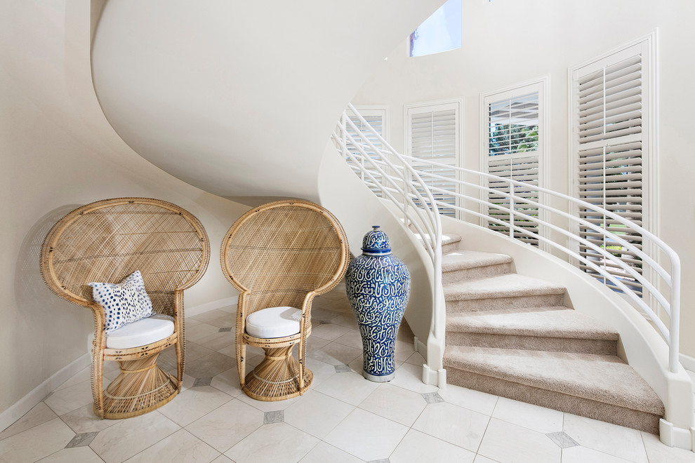 Inspiration for a beach style carpeted spiral staircase in Los Angeles with carpet risers.