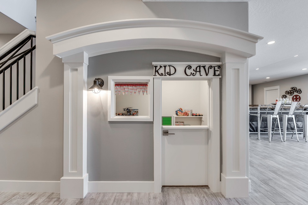 This is an example of a mid-sized traditional kids' playroom for kids 4-10 years old in Salt Lake City with grey walls, laminate floors and grey floor.
