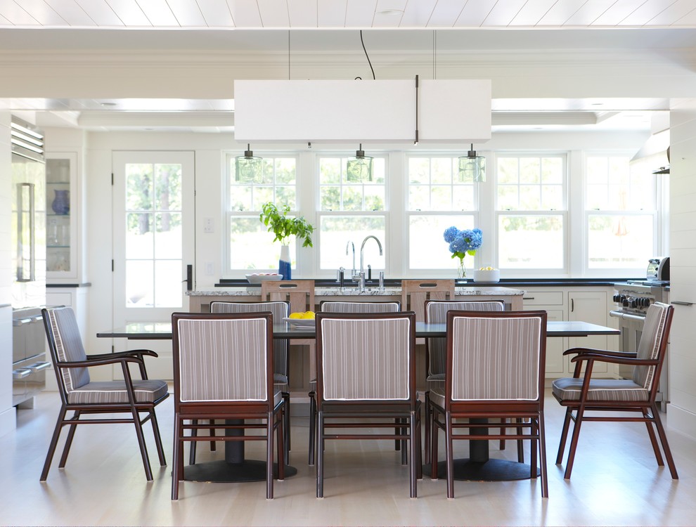 Mid-sized beach style kitchen/dining combo in Boston with light hardwood floors, white walls and beige floor.