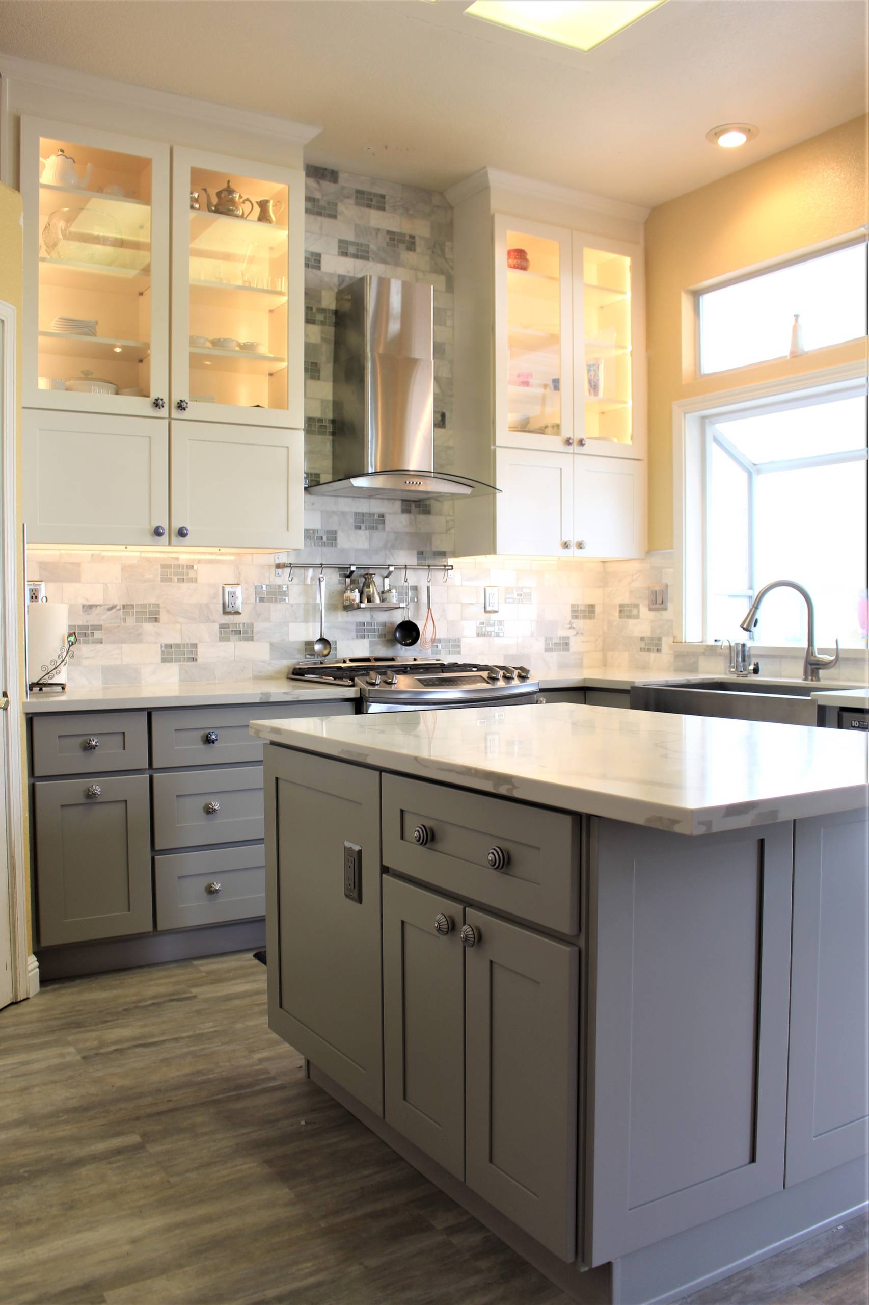 Kitchen - mid-sized transitional u-shaped medium tone wood floor and gray floor kitchen idea in Sacramento with a farmhouse sink, shaker cabinets, gray cabinets, marble countertops, gray backsplash, m