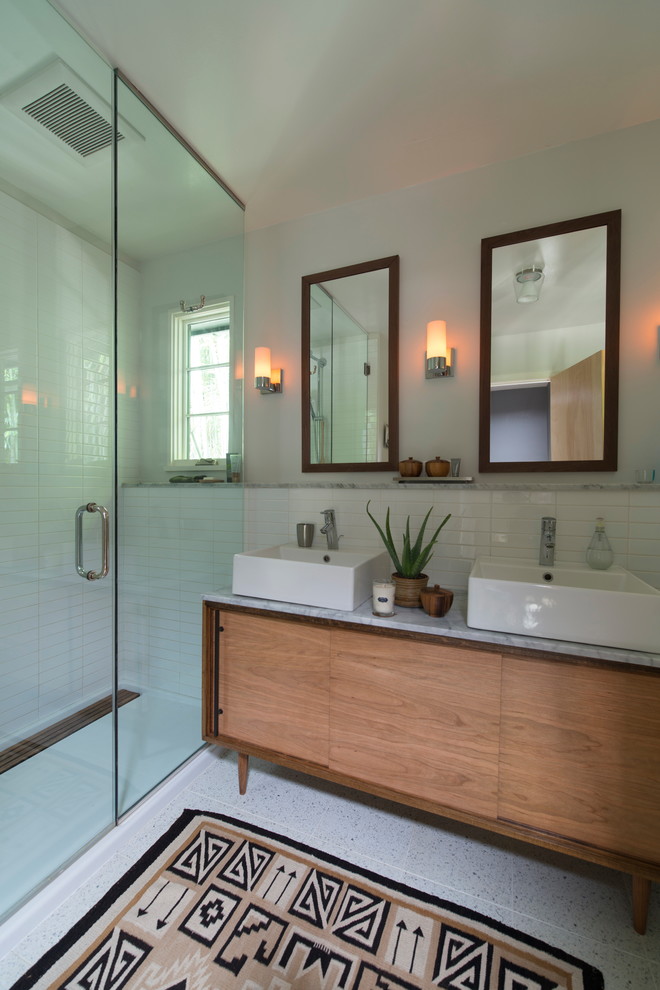 Photo of a mid-sized transitional master bathroom in DC Metro with a vessel sink, medium wood cabinets, marble benchtops, an alcove shower, white tile, ceramic tile, grey walls and flat-panel cabinets.