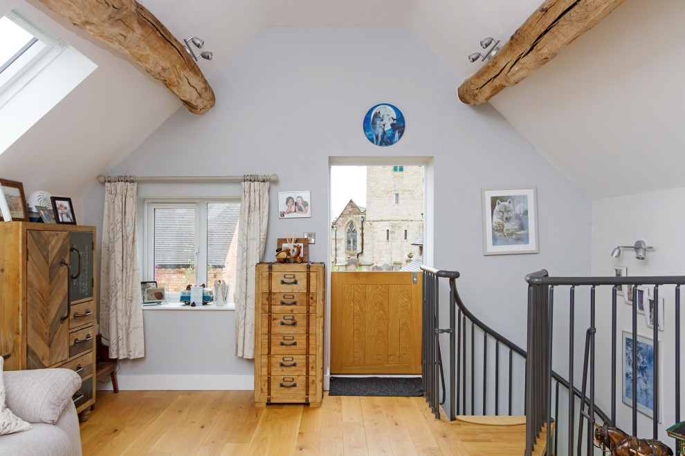 Photo of a small rustic formal open plan living room in West Midlands with purple walls, light hardwood flooring, a wood burning stove, a freestanding tv, beige floors and exposed beams.