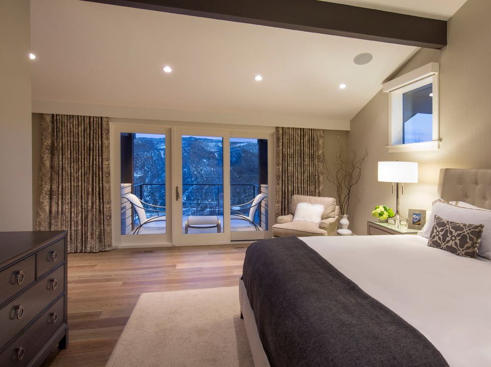 Example of a large transitional master medium tone wood floor and brown floor bedroom design in Denver with beige walls