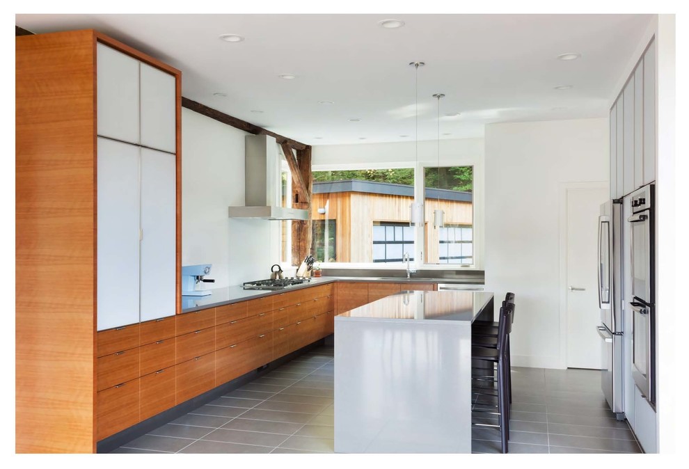 Large contemporary l-shaped eat-in kitchen in Bridgeport with flat-panel cabinets, medium wood cabinets, stainless steel appliances and with island.