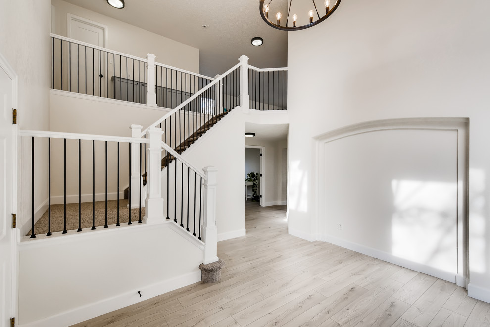 Example of a large minimalist vinyl floor, gray floor and wallpaper entryway design in Denver with white walls and a white front door