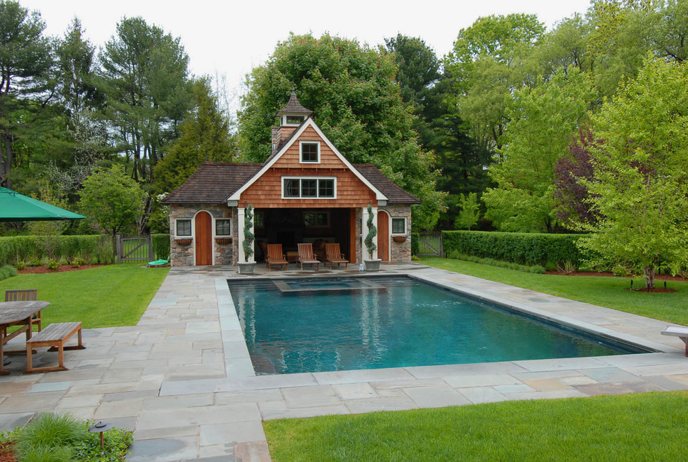 Inspiration for a mid-sized timeless backyard stone and rectangular pool house remodel in Other