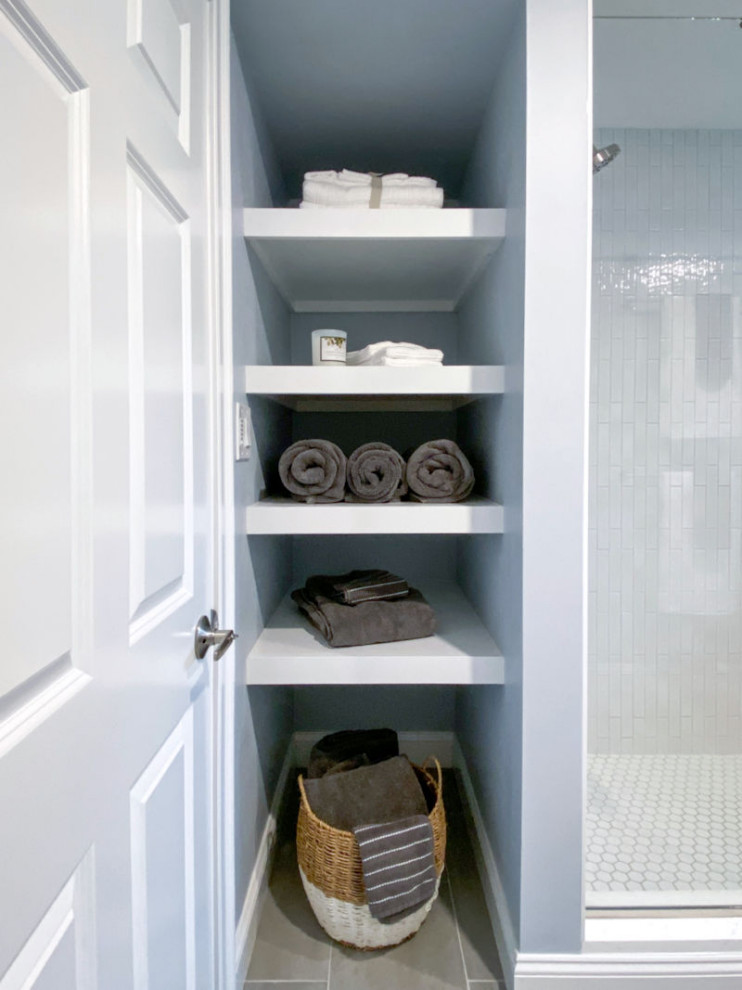 Inspiration for a transitional white tile and ceramic tile porcelain tile, gray floor and single-sink corner shower remodel in Boston with shaker cabinets, gray cabinets, a one-piece toilet, gray walls, an undermount sink, quartz countertops, a hinged shower door, white countertops and a built-in vanity
