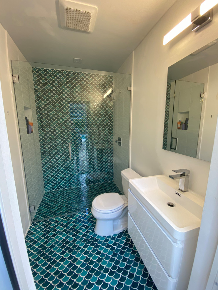 Small traditional 3/4 bathroom in Miami with flat-panel cabinets, white cabinets, a curbless shower, a two-piece toilet, blue tile, mosaic tile, white walls, mosaic tile floors, an integrated sink, blue floor, a hinged shower door, white benchtops, a single vanity and a floating vanity.