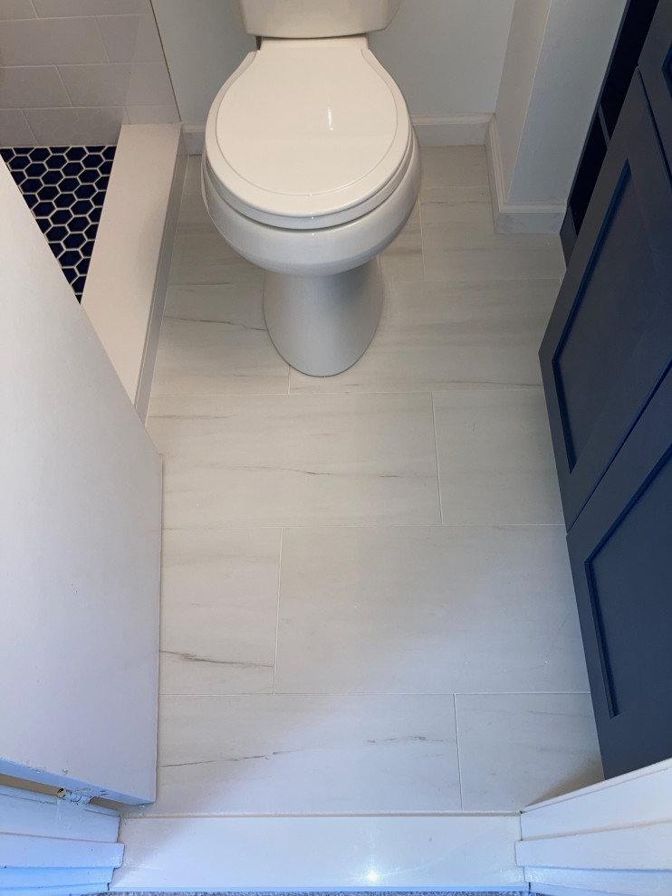 Small modern 3/4 bathroom in DC Metro with shaker cabinets, blue cabinets, an alcove shower, a two-piece toilet, white tile, porcelain tile, white walls, porcelain floors, an undermount sink, quartzite benchtops, white floor, a shower curtain, white benchtops, a single vanity and a built-in vanity.