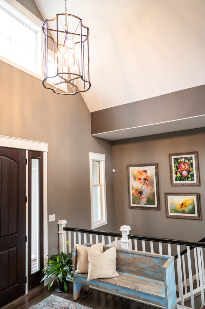 Mittelgroße Moderne Haustür mit brauner Wandfarbe, braunem Holzboden, Einzeltür, brauner Haustür, braunem Boden und gewölbter Decke in Cedar Rapids
