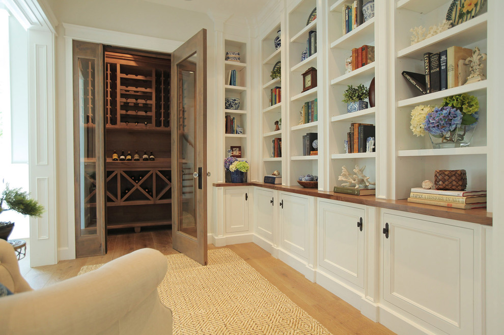 Photo of a mid-sized country wine cellar in Los Angeles with light hardwood floors, storage racks and brown floor.