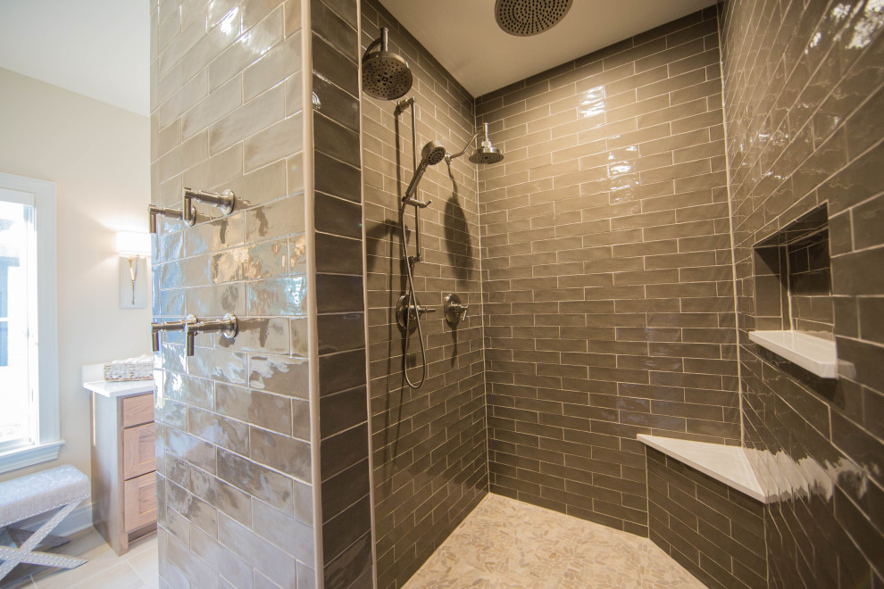 Photo of a large classic ensuite bathroom in Indianapolis with raised-panel cabinets, medium wood cabinets, a built-in shower, grey tiles, metro tiles, white walls, porcelain flooring, a submerged sink, granite worktops, brown floors, an open shower, white worktops, double sinks and a freestanding vanity unit.