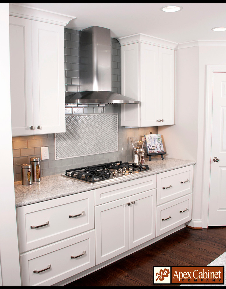 Inspiration for a mid-sized l-shaped dark wood floor kitchen remodel in Raleigh with a double-bowl sink, shaker cabinets, white cabinets, quartzite countertops, gray backsplash, subway tile backsplash, stainless steel appliances and an island