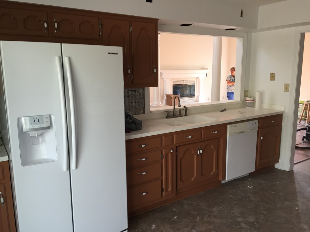 Home design - mid-sized transitional galley vinyl floor home design idea with a farmhouse sink, raised-panel cabinets, beige cabinets, solid surface countertops, multicolored backsplash, stone tile backsplash, stainless steel appliances and no island