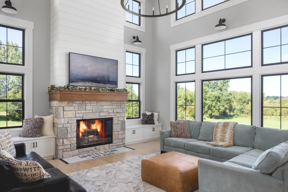 Inspiration for a large country open plan living room in Milwaukee with grey walls, light hardwood flooring, a standard fireplace, a stone fireplace surround and brown floors.