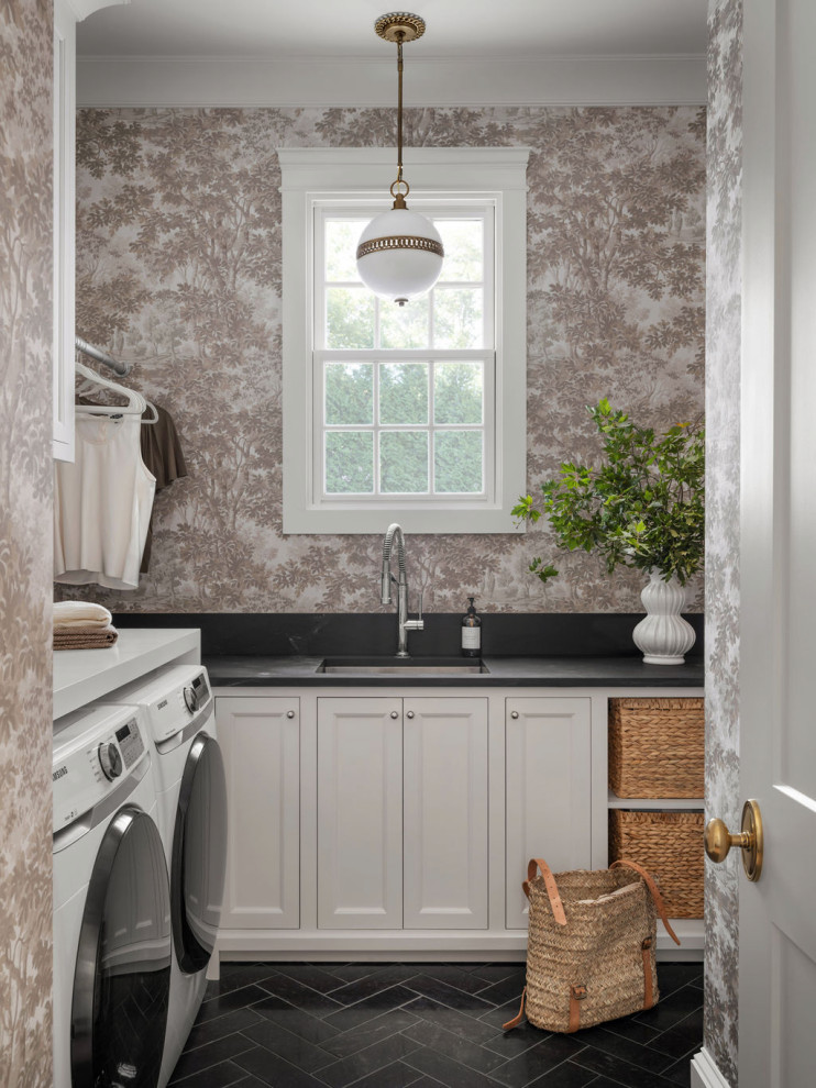 Elegant l-shaped black floor and wallpaper laundry room photo in Atlanta with an undermount sink, recessed-panel cabinets, white cabinets, multicolored walls, a side-by-side washer/dryer and black countertops