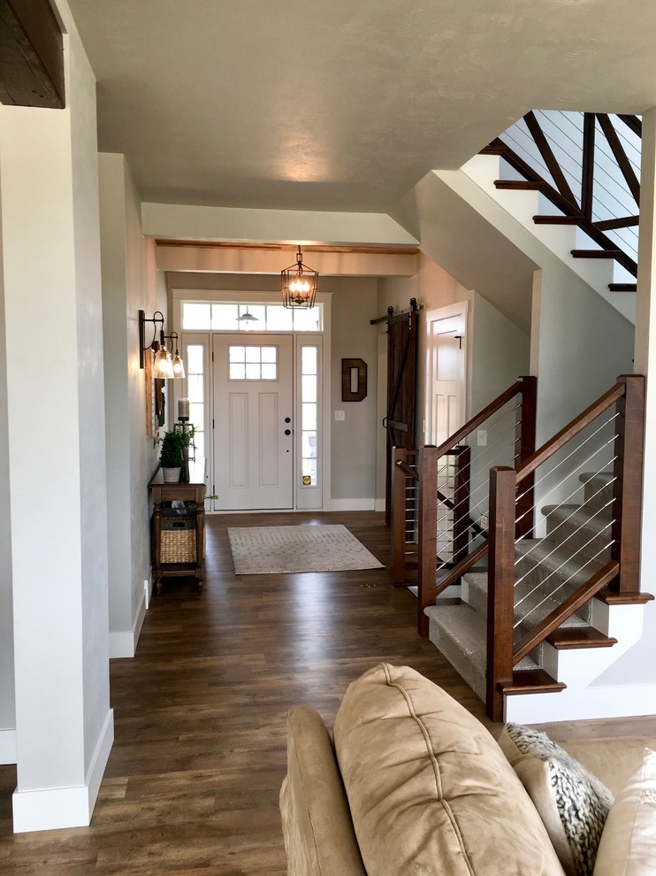 This is an example of a large country foyer in Other with grey walls, vinyl floors, a single front door, a white front door and brown floor.