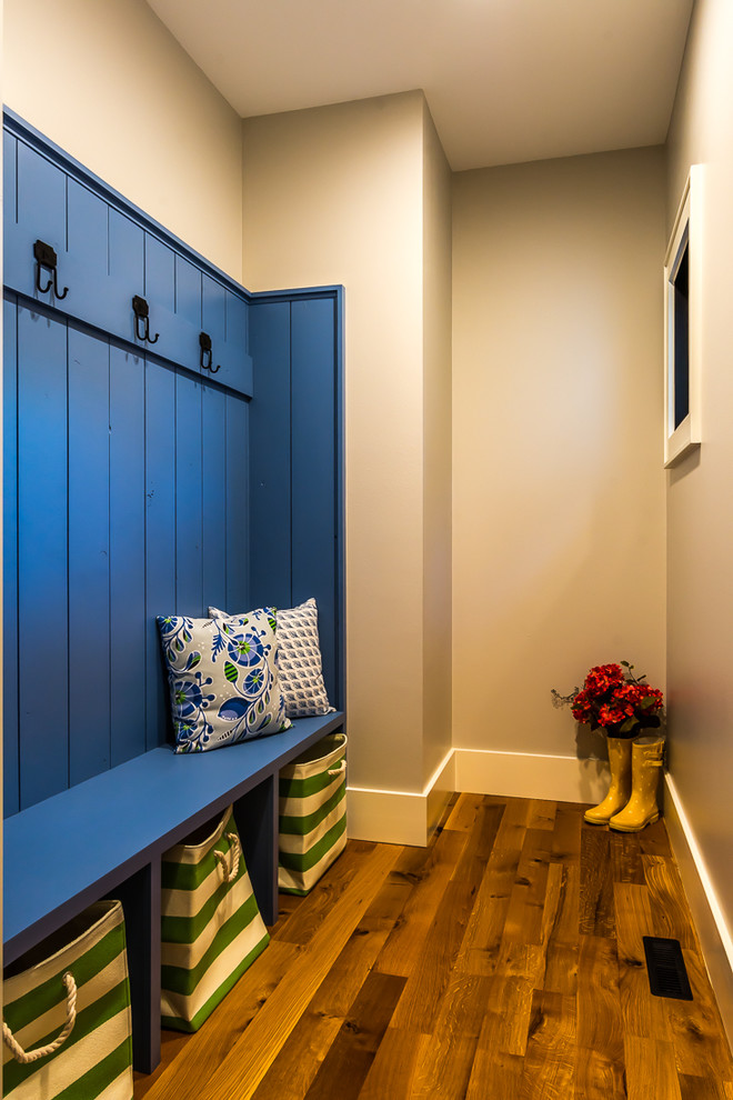 Mudroom - large transitional medium tone wood floor mudroom idea in Cedar Rapids with white walls