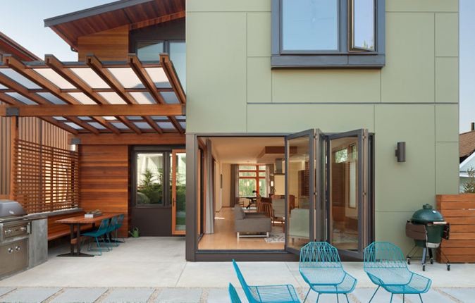 This is an example of a mid-sized modern two-storey green house exterior in Seattle.